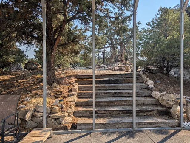 Tiered landscape featuring natural rock formations and mature evergreen trees