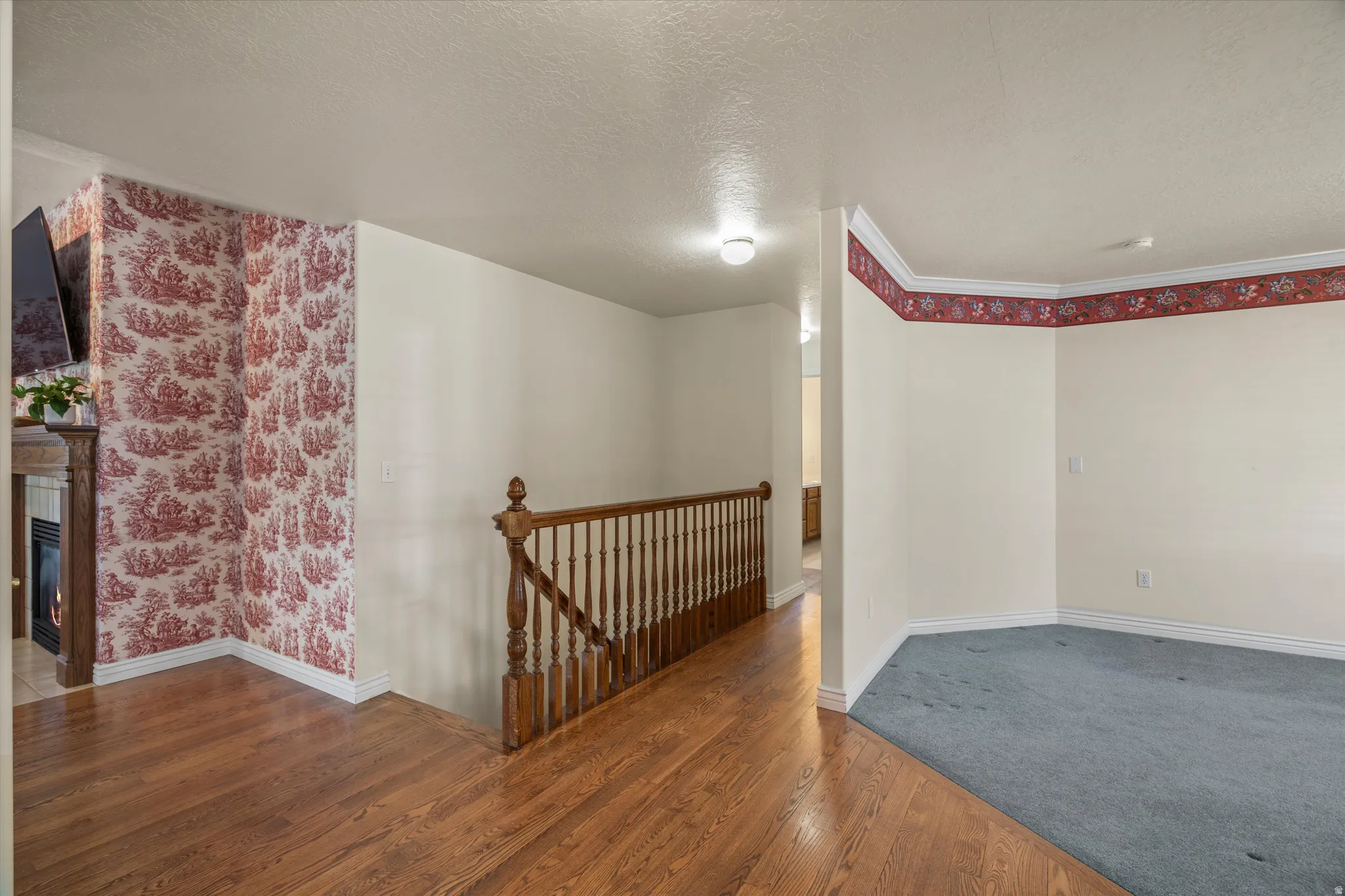 Hardwood flooring at the entry, featuring a wood banister and white trim