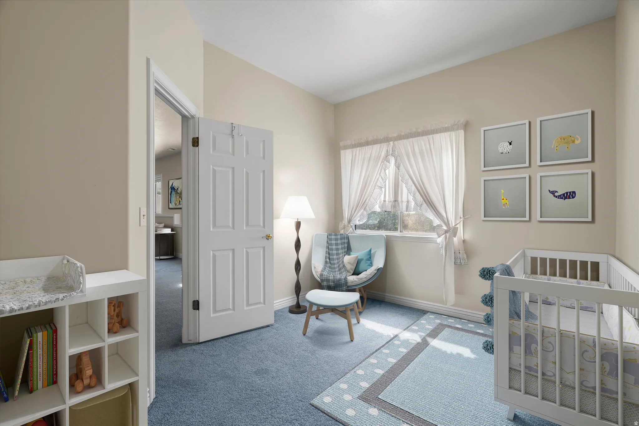 Comfortable room with soft blue carpeting and a window featuring sheer white curtains
