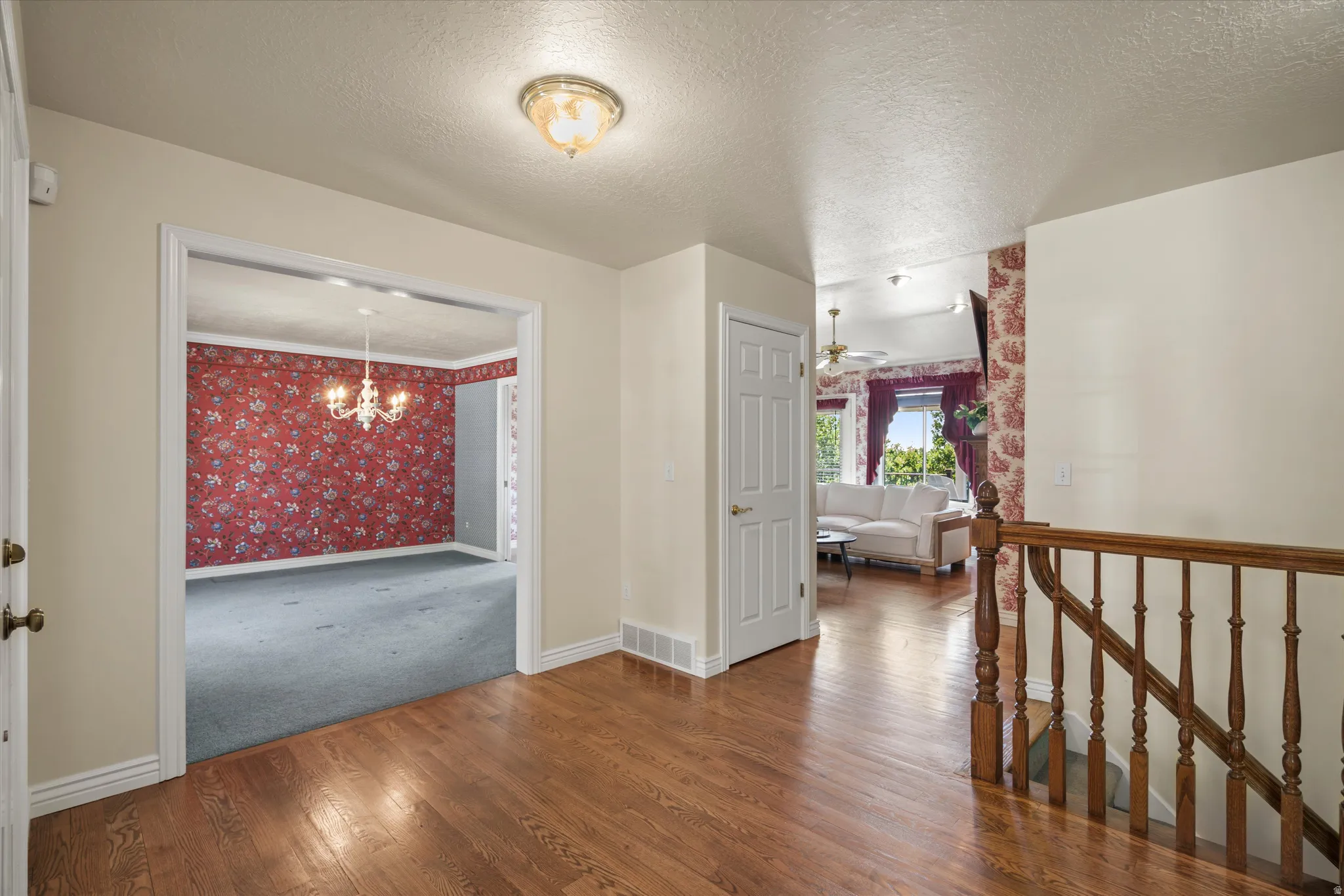 Entryway featuring wood-finish flooring, a decorative overhead light fixture, and a wooden stair railing