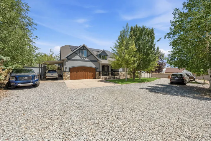 Inviting exterior with gray siding, stone accents, and a wood-finish garage door