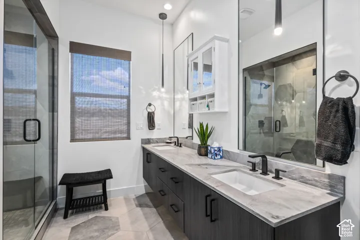 Dual floating vanities with undermount sinks, stone countertops, and matte black fixtures