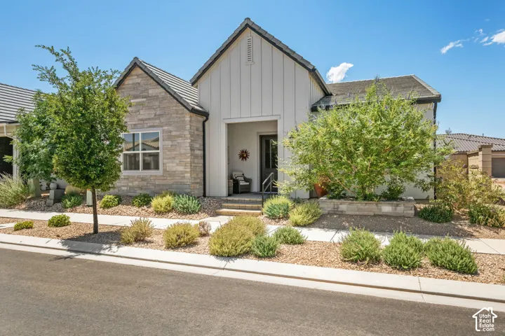 Modern farmhouse exterior featuring vertical white siding and stone accents