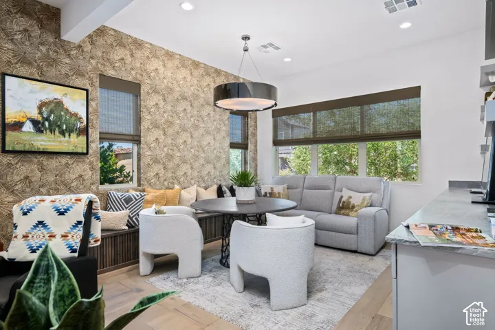 Recessed lighting, wood-finish flooring, built-in window seating, textured accent wall, and a contemporary chandelier