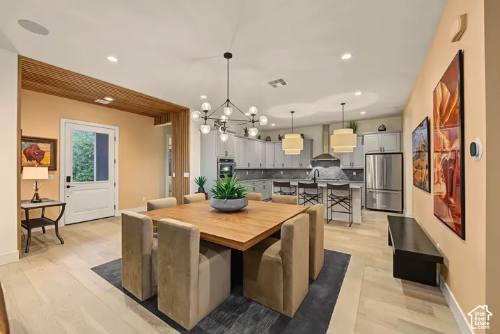 Light wood-finish flooring throughout, modern kitchen with stainless steel appliances, contemporary pendant lighting, recessed ceiling lights, and wood slat ceiling detail