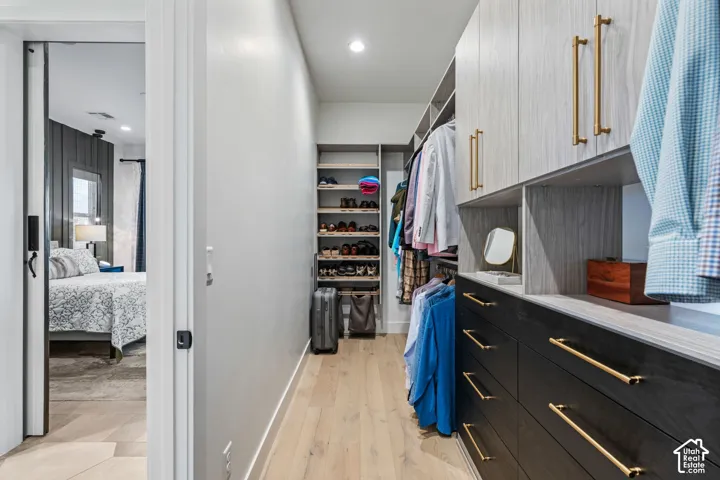 Wood-finish flooring throughout, recessed lighting, built-in shelving, and built-in cabinetry with gold-tone hardware