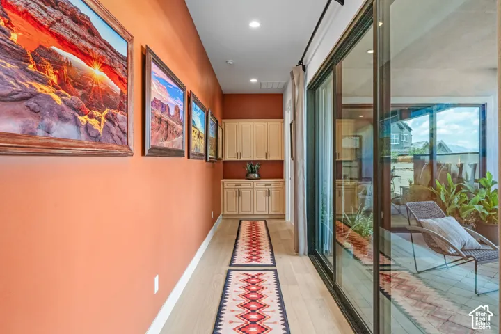 Hallway featuring wood-finish flooring and built-in cabinetry