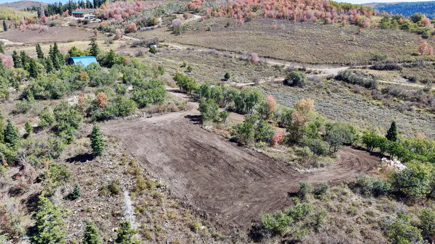 Cleared building site featuring a flat pad and surrounding natural landscape