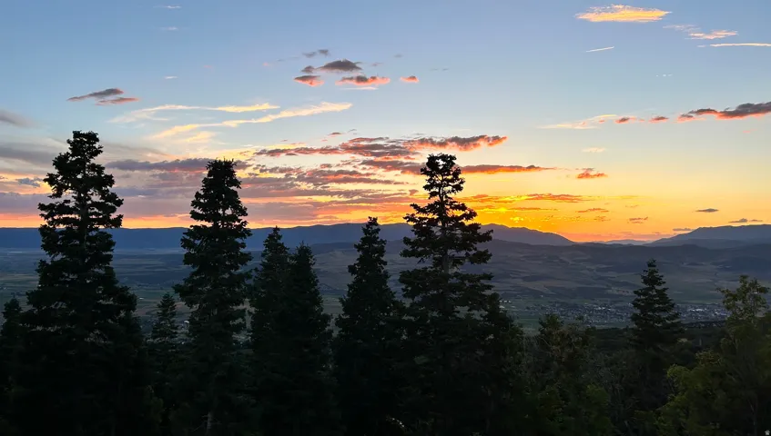 Expansive western horizon with a vibrant sunset and distant mountain ranges
