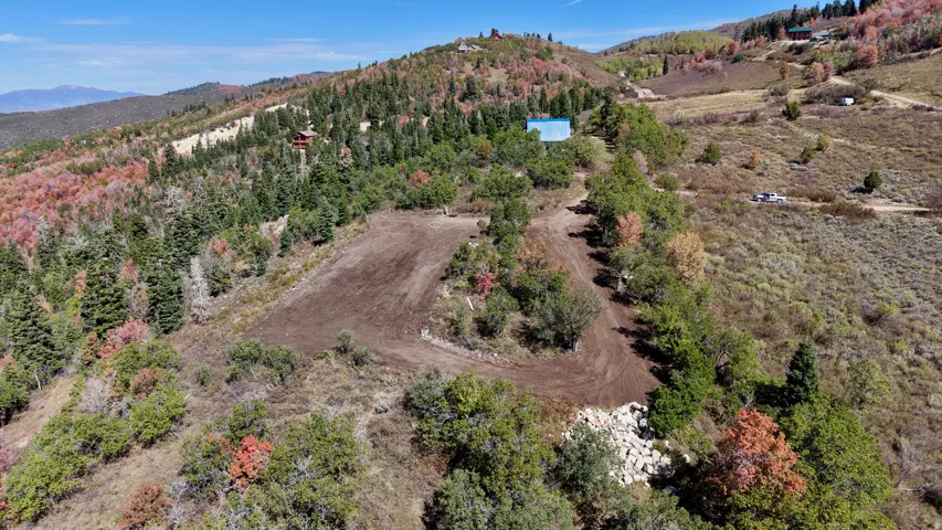 Mountainous terrain with natural tree coverage and a cleared building site