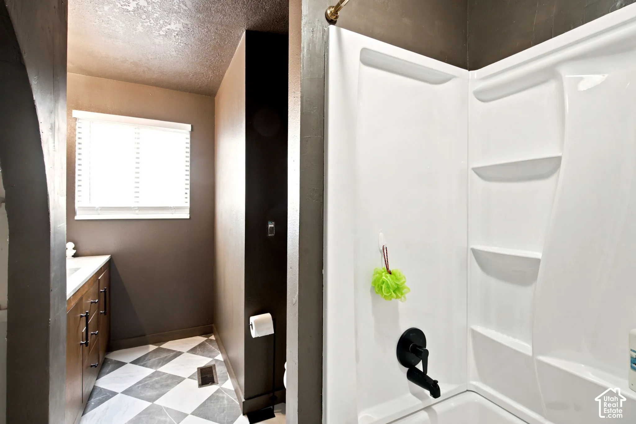 Bathroom featuring a white bathtub and shower surround with integrated shelving