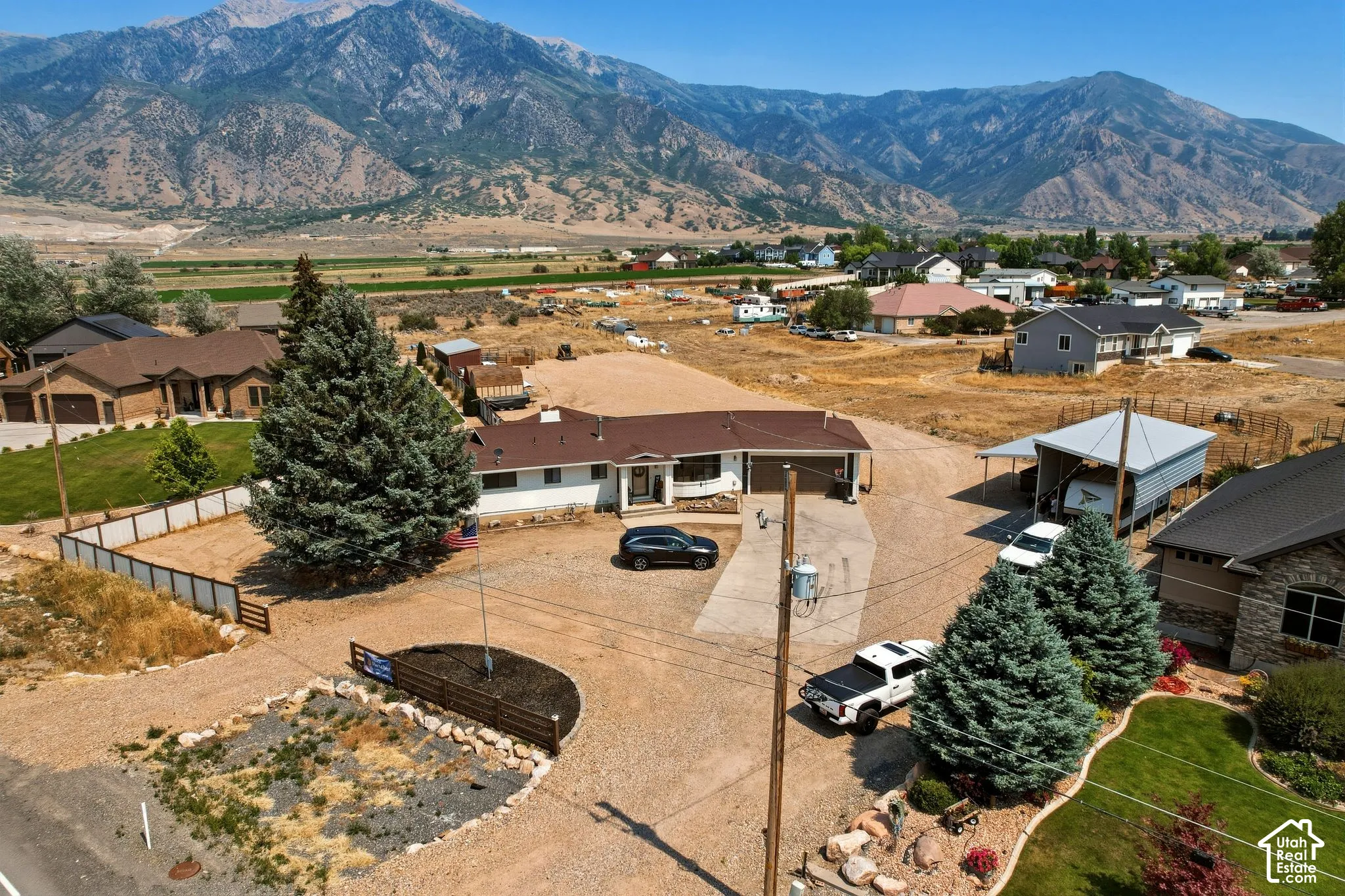 Ranch-style residence featuring a brown shingle roof, white exterior siding, and an attached carport