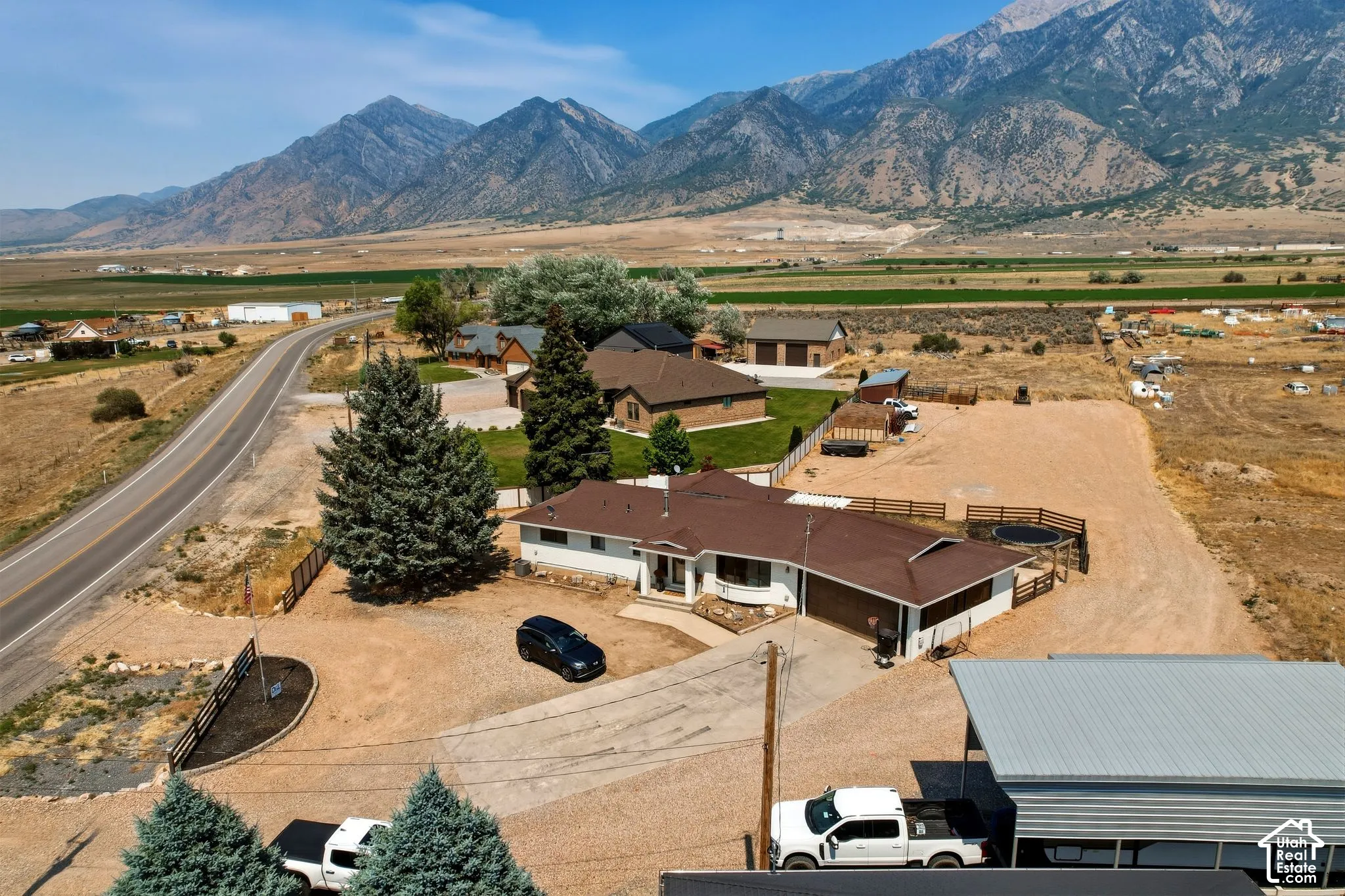 Ranch-style residence featuring a prominent brown roof, attached garage, and a gravel driveway