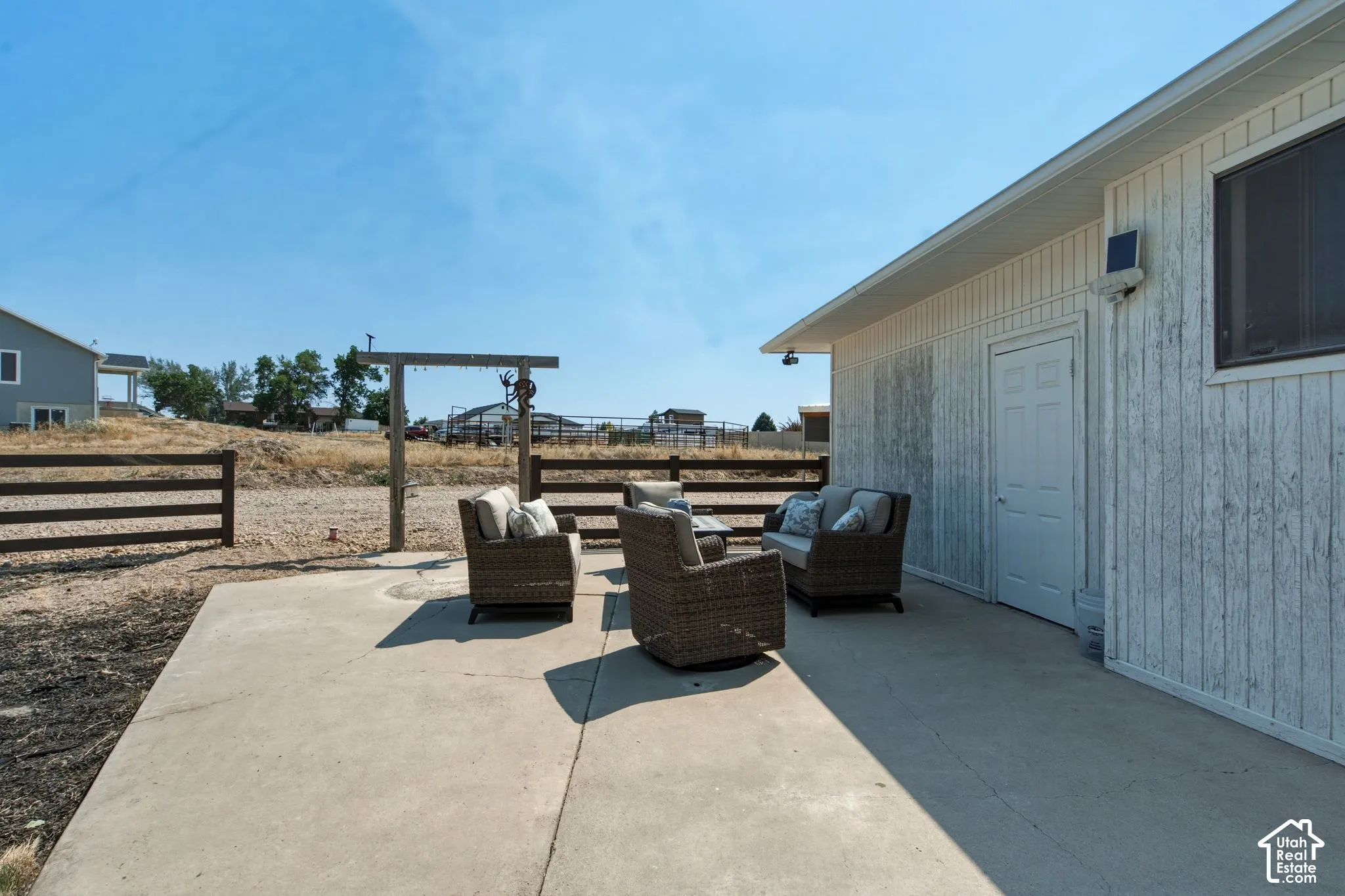 Concrete patio area featuring a white paneled exterior wall and a privacy window