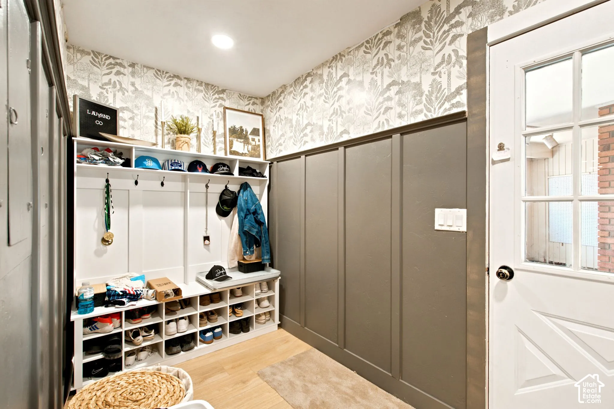 Custom built-in mudroom storage featuring a bench, individual shoe cubbies, and coat hooks
