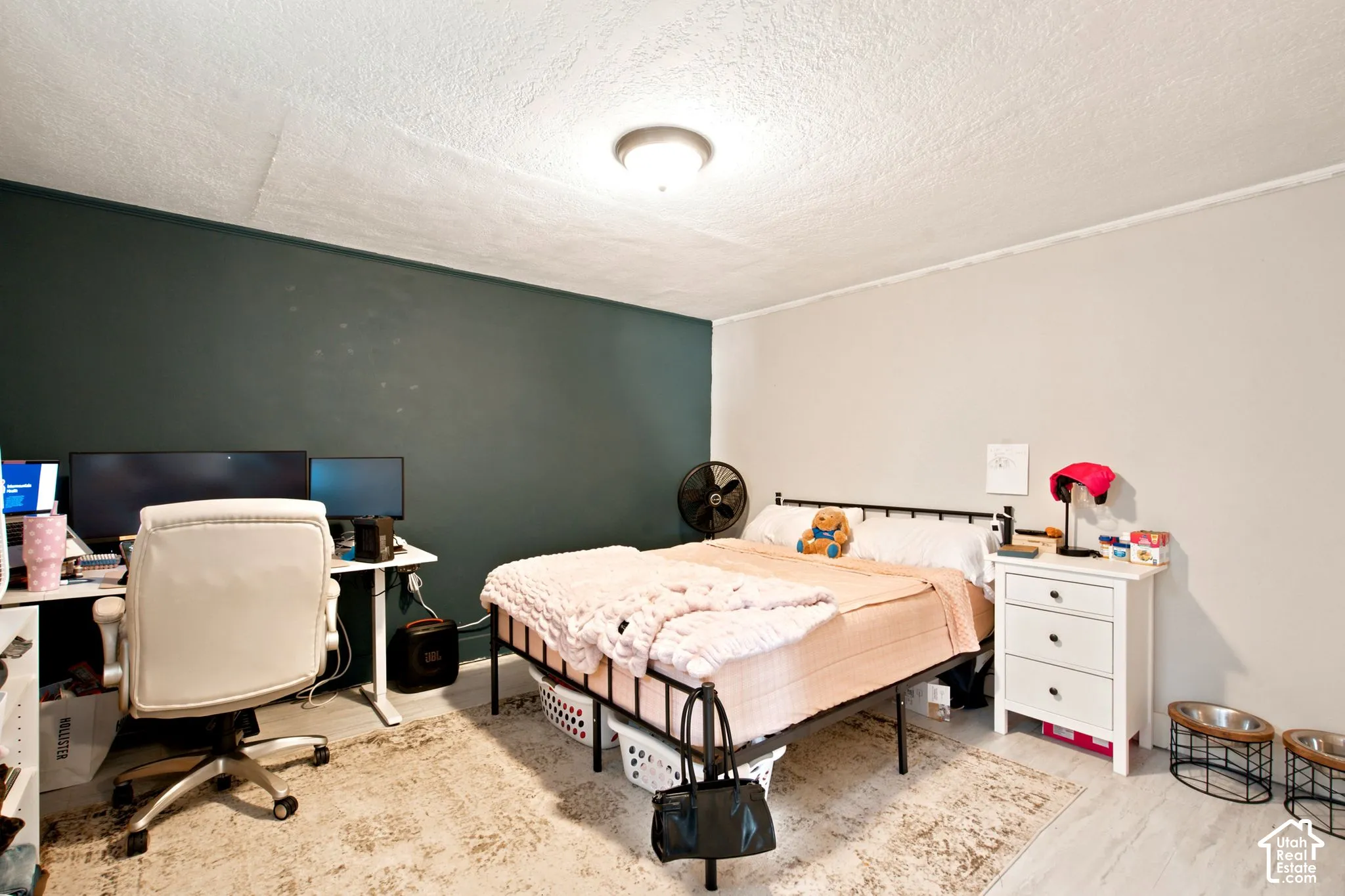 Room featuring two-tone wall paint, a ceiling-mounted light fixture, and light-toned flooring