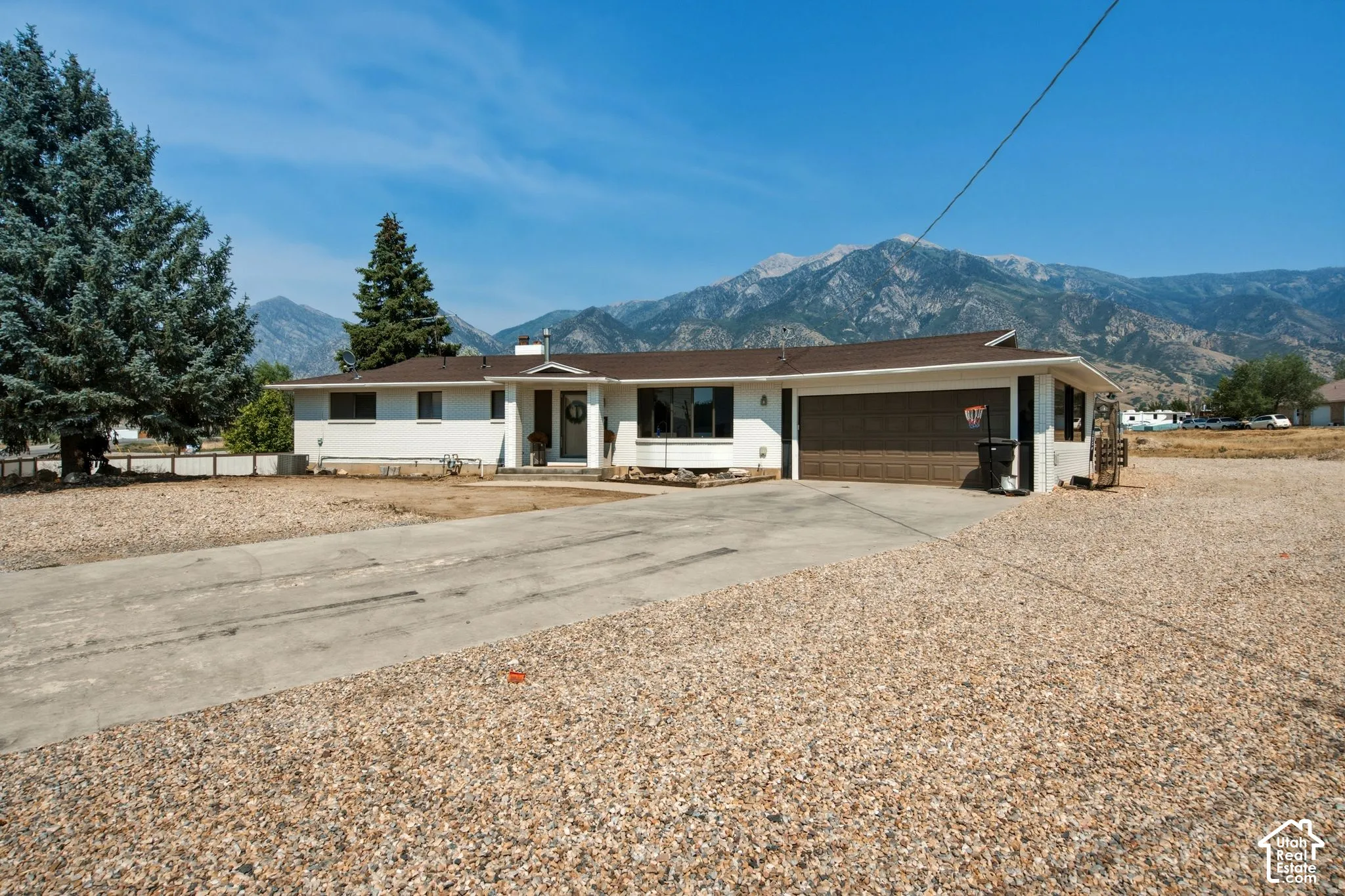Single-story residence featuring a two-car garage and a gravel-covered front yard