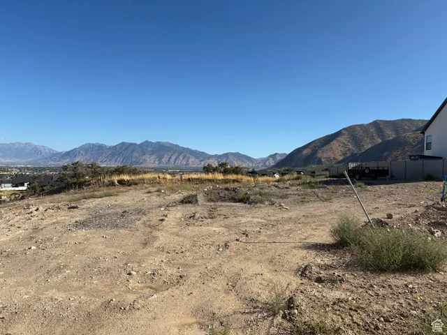 Expansive building lot featuring distant mountain scenery and a clear sky backdrop