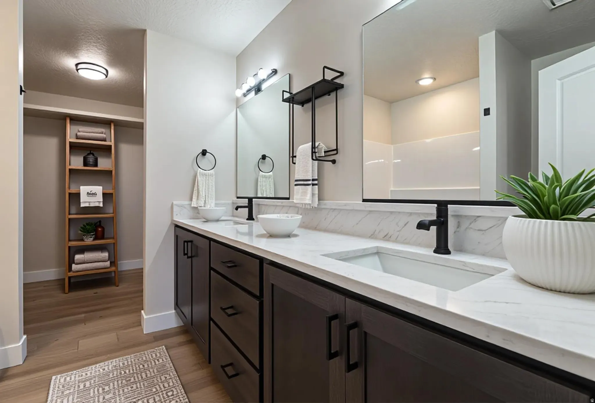 Digitally Staged-Dual vanity with undermount sinks, white countertop, and dark wood-finish cabinetry