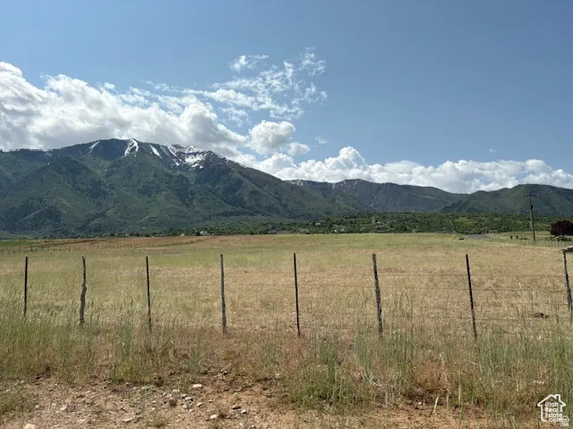 Expansive land parcel featuring open fields and a distant mountain range with snow-capped peaks