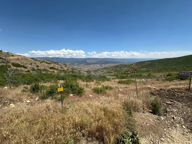 Expansive land parcel featuring natural terrain and distant mountainous horizons