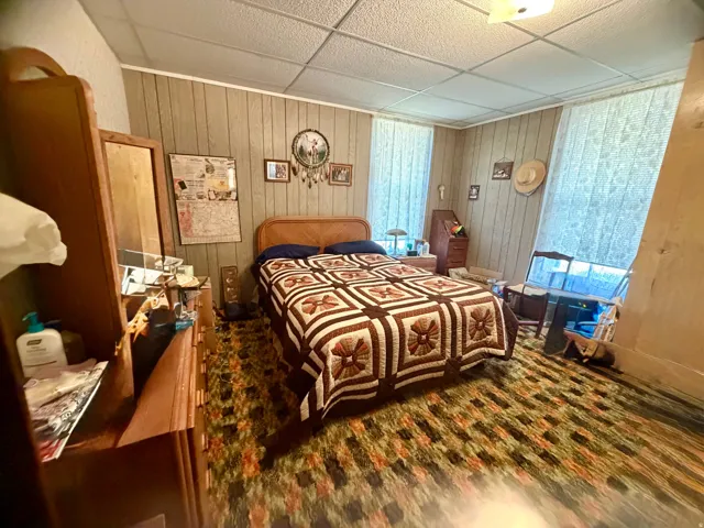 Room featuring vertical paneled wall treatments and two windows