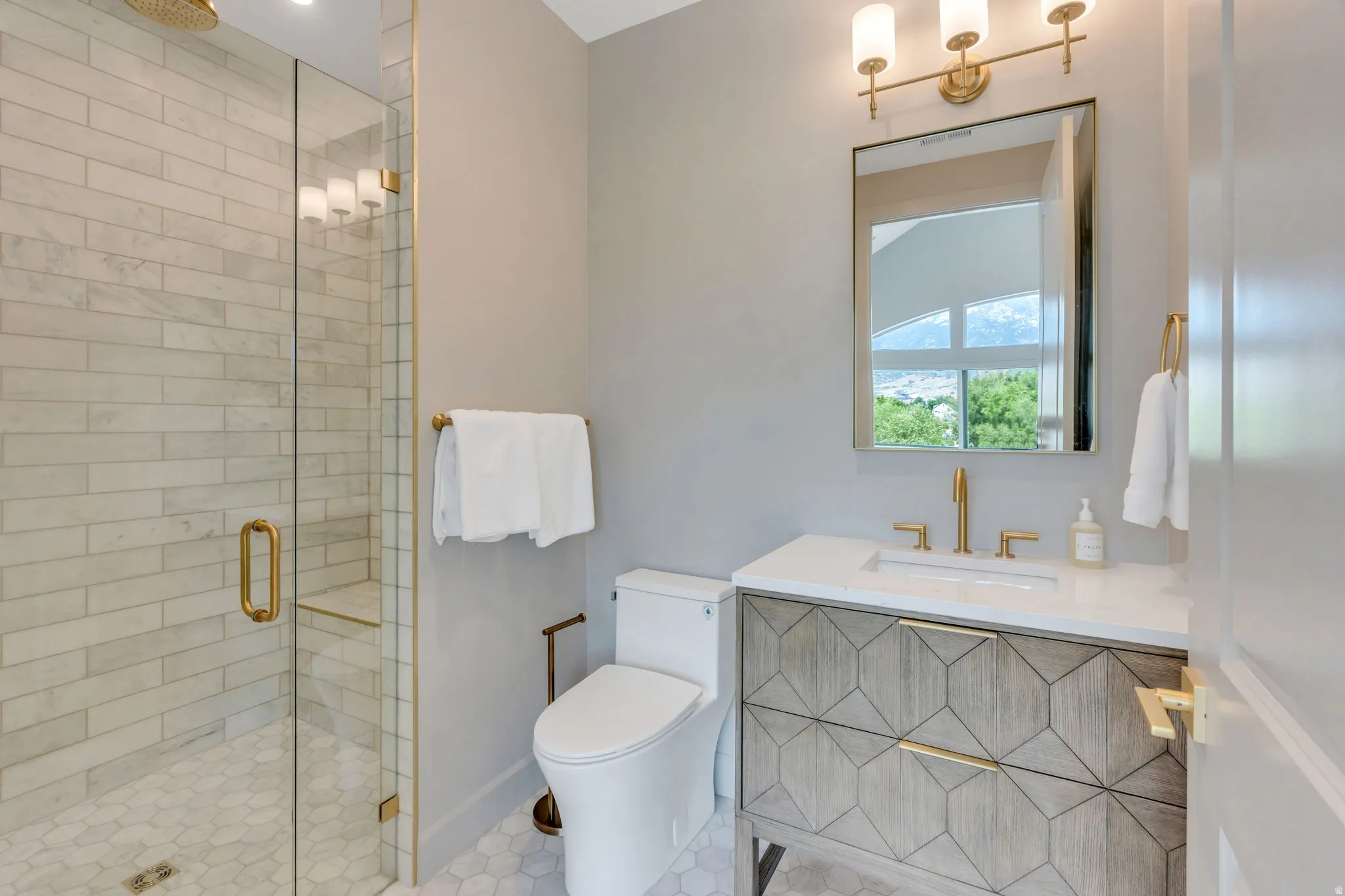 Contemporary bathroom featuring a geometric-patterned vanity with a white countertop and undermount sink