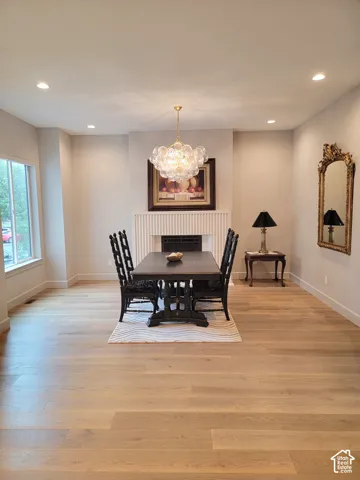 Neutral-toned interior featuring wood-finish flooring, recessed lighting, and a focal fireplace with vertical slat detailing