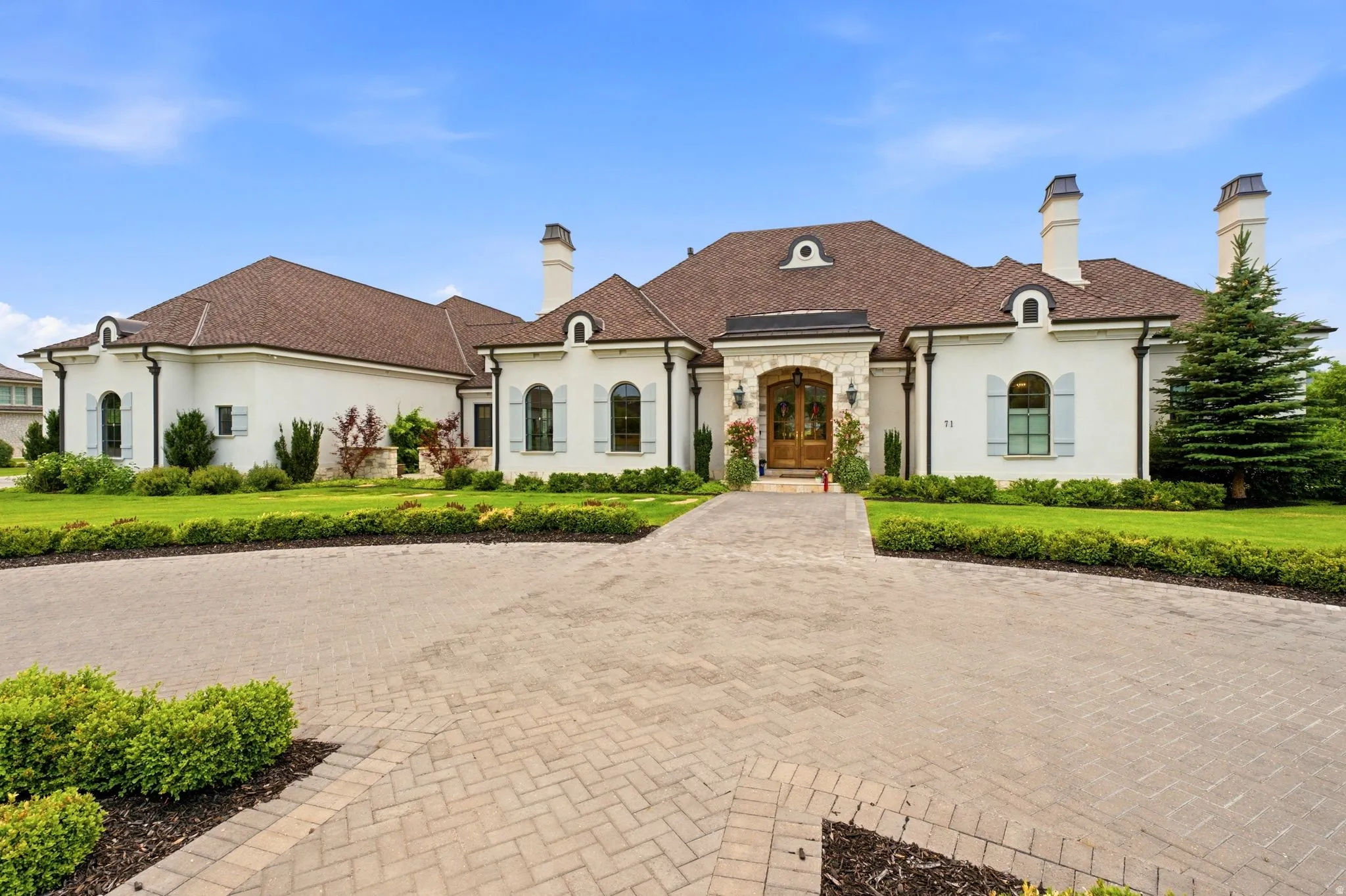 Stucco exterior residence with a brown tile roof and multiple chimneys