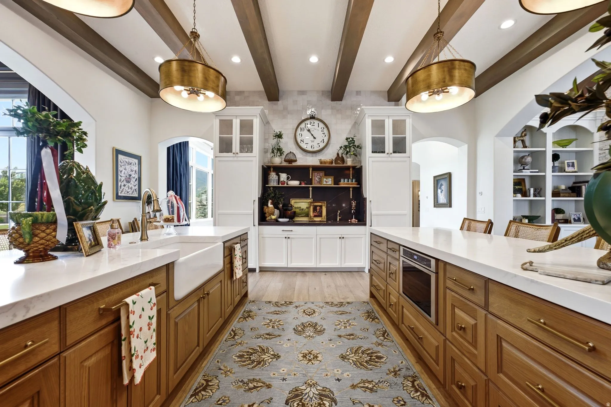 Gourmet kitchen with double islands, wood-finish flooring, exposed beam ceilings, and white countertops