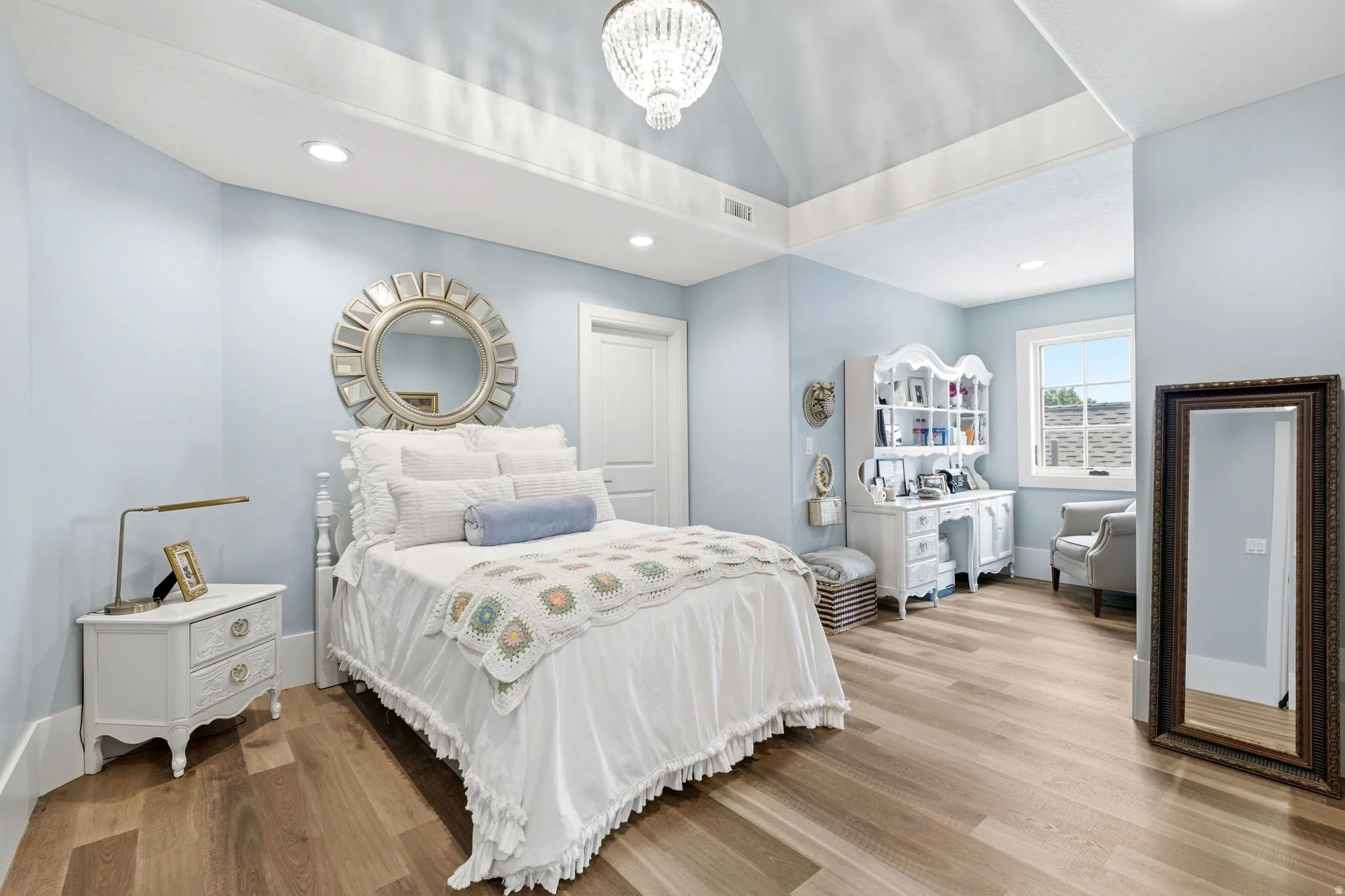 Vaulted ceiling with a central chandelier and recessed lighting