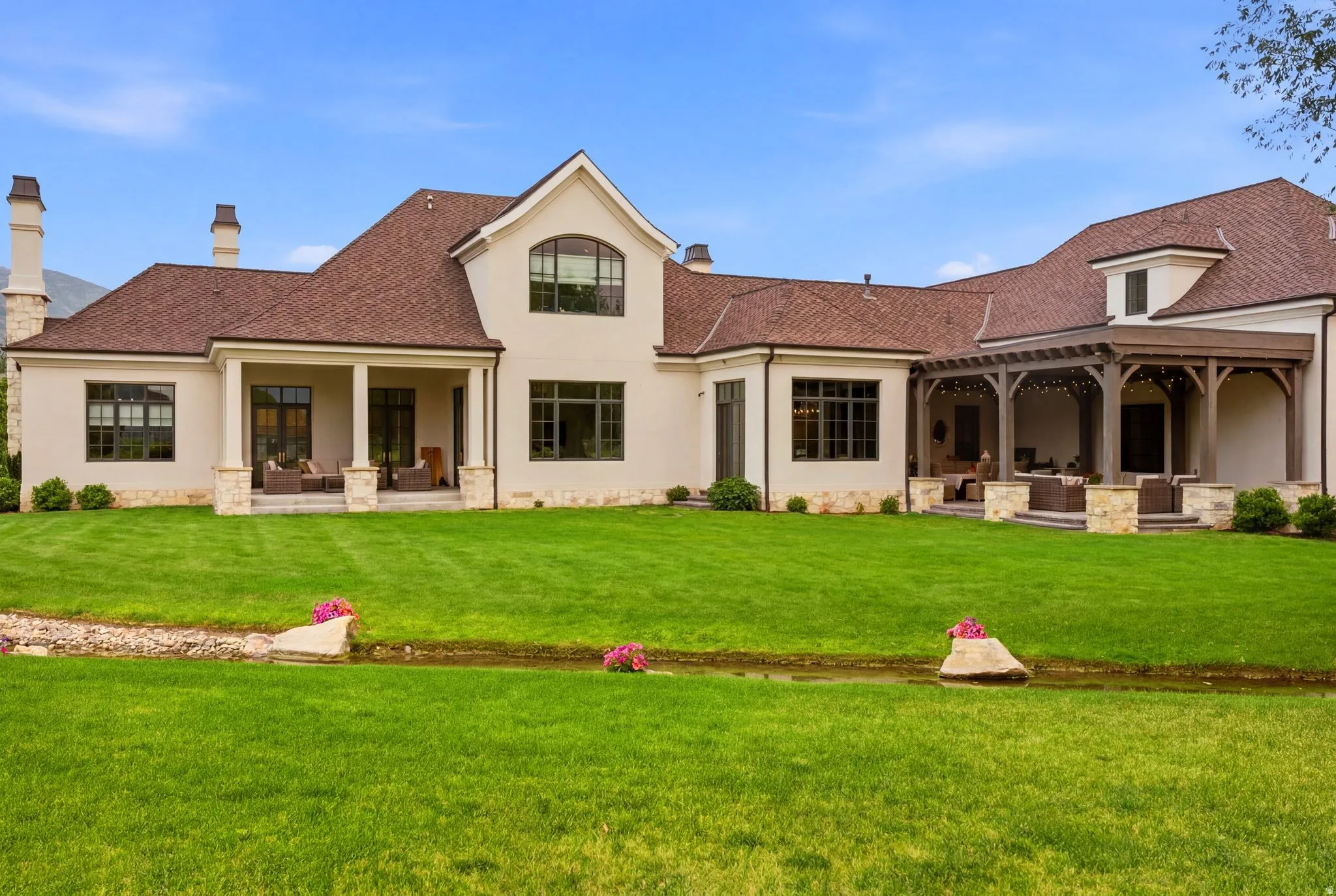 Expansive green lawn with a natural water feature