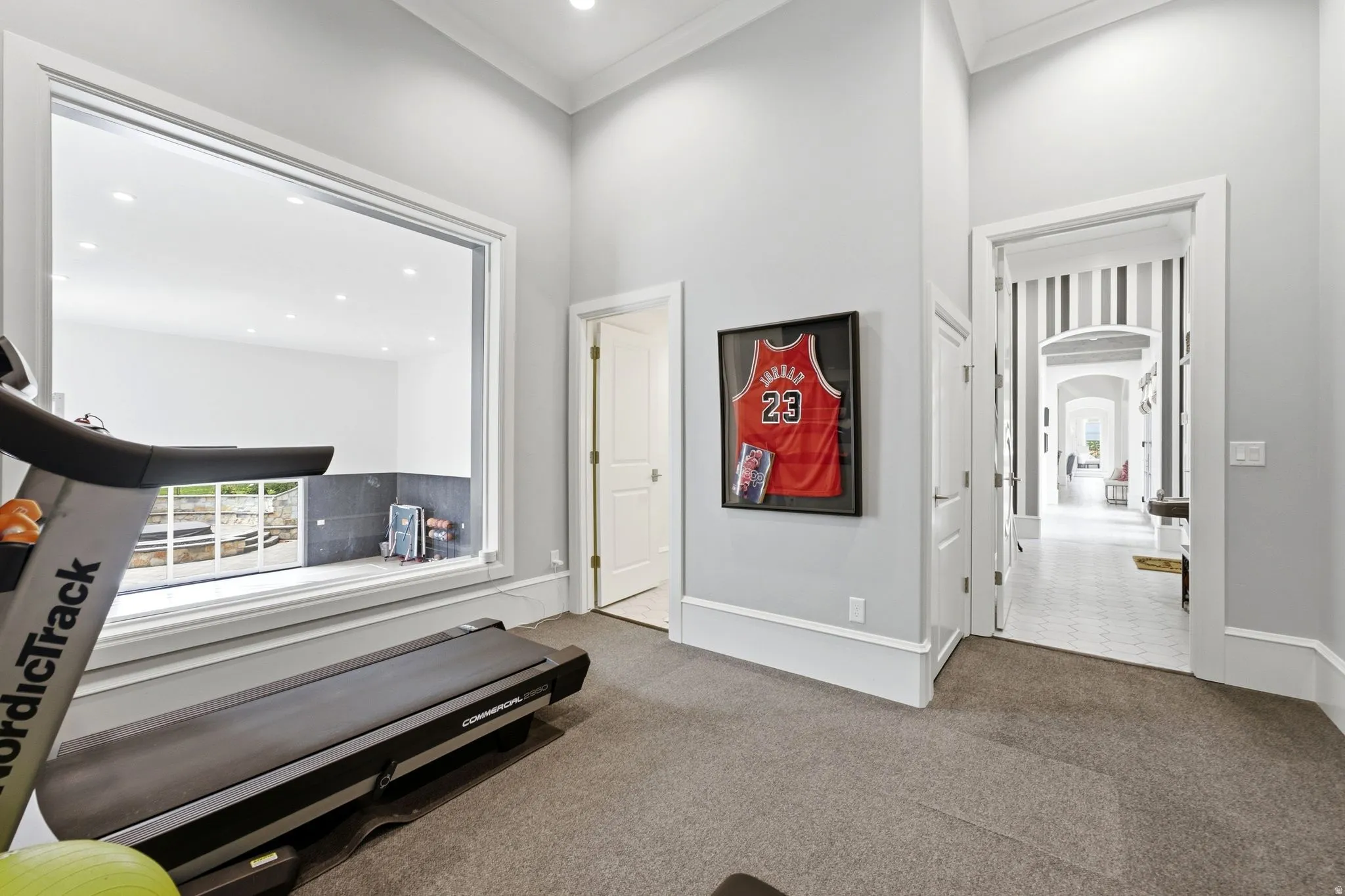 Dedicated room featuring a large picture window, light gray walls, white trim, and recessed lighting