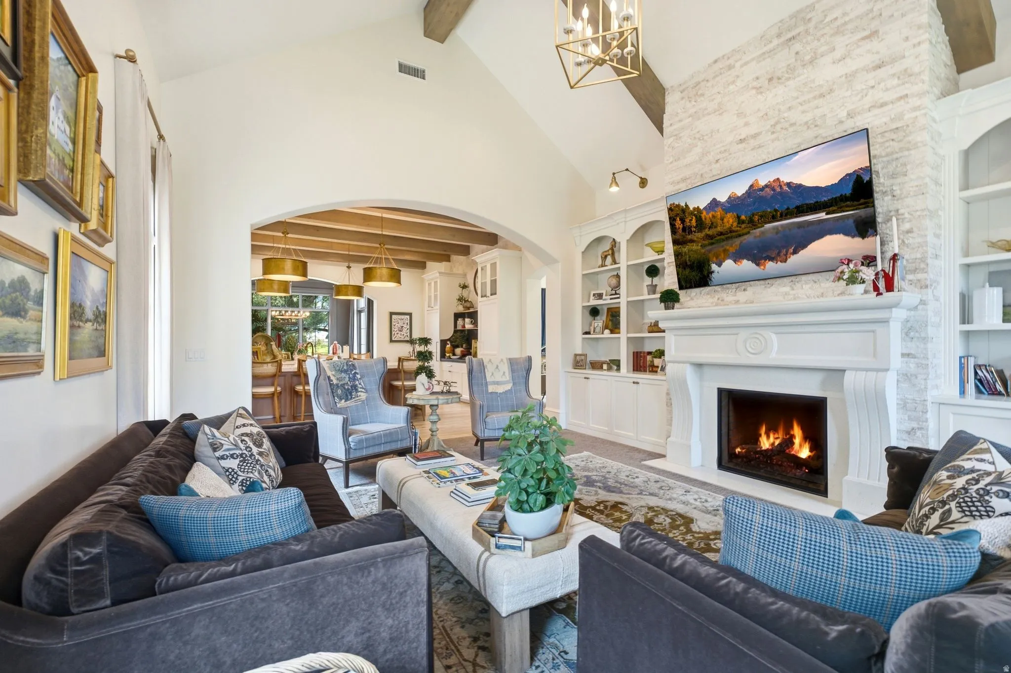 Spacious living area featuring a prominent fireplace with a substantial mantel, flanked by built-in white cabinetry