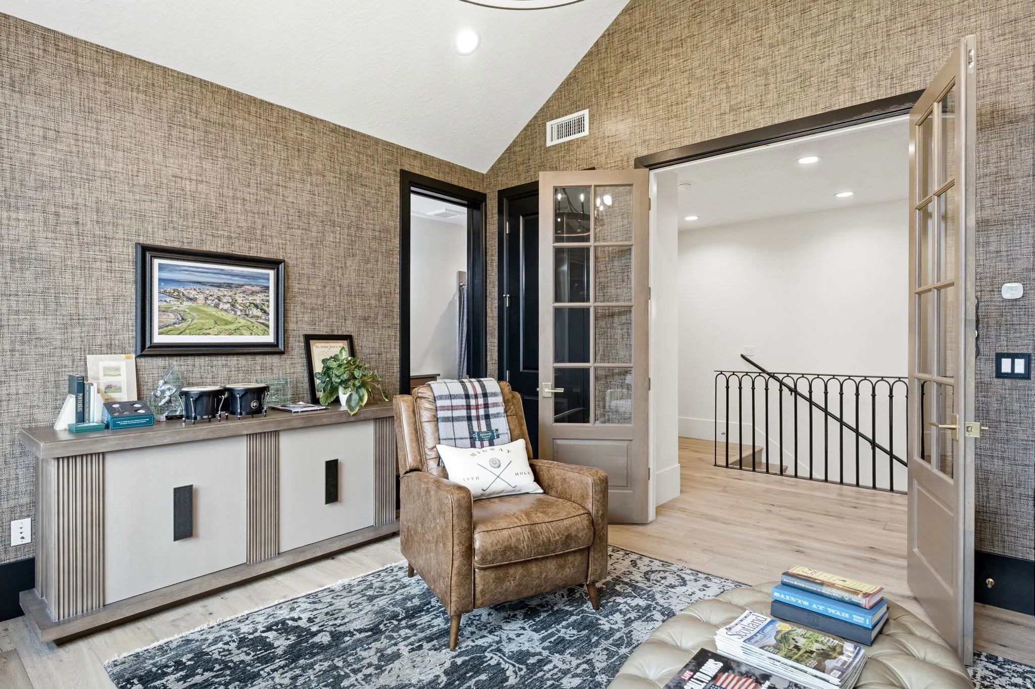 Vaulted ceiling office space featuring accent wallpaper