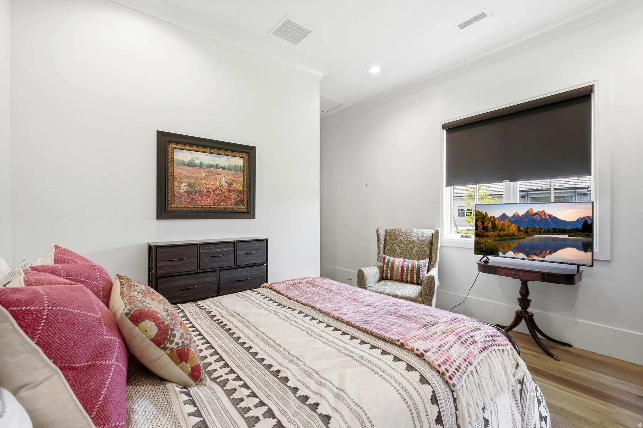 Bedroom featuring a window with roller shade, recessed lighting, and wood-finish flooring
