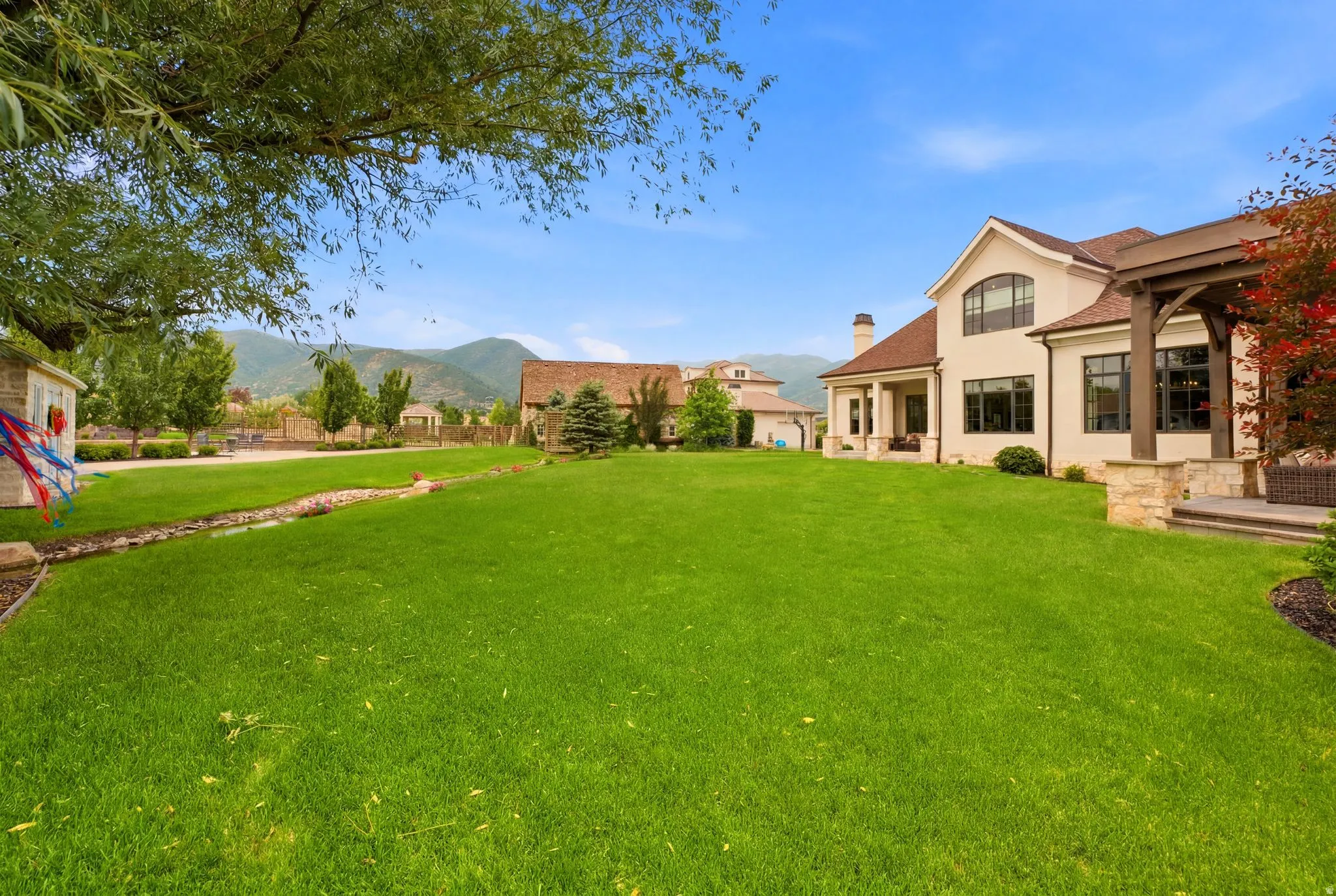 Expansive green lawn bordering a stucco and stone exterior