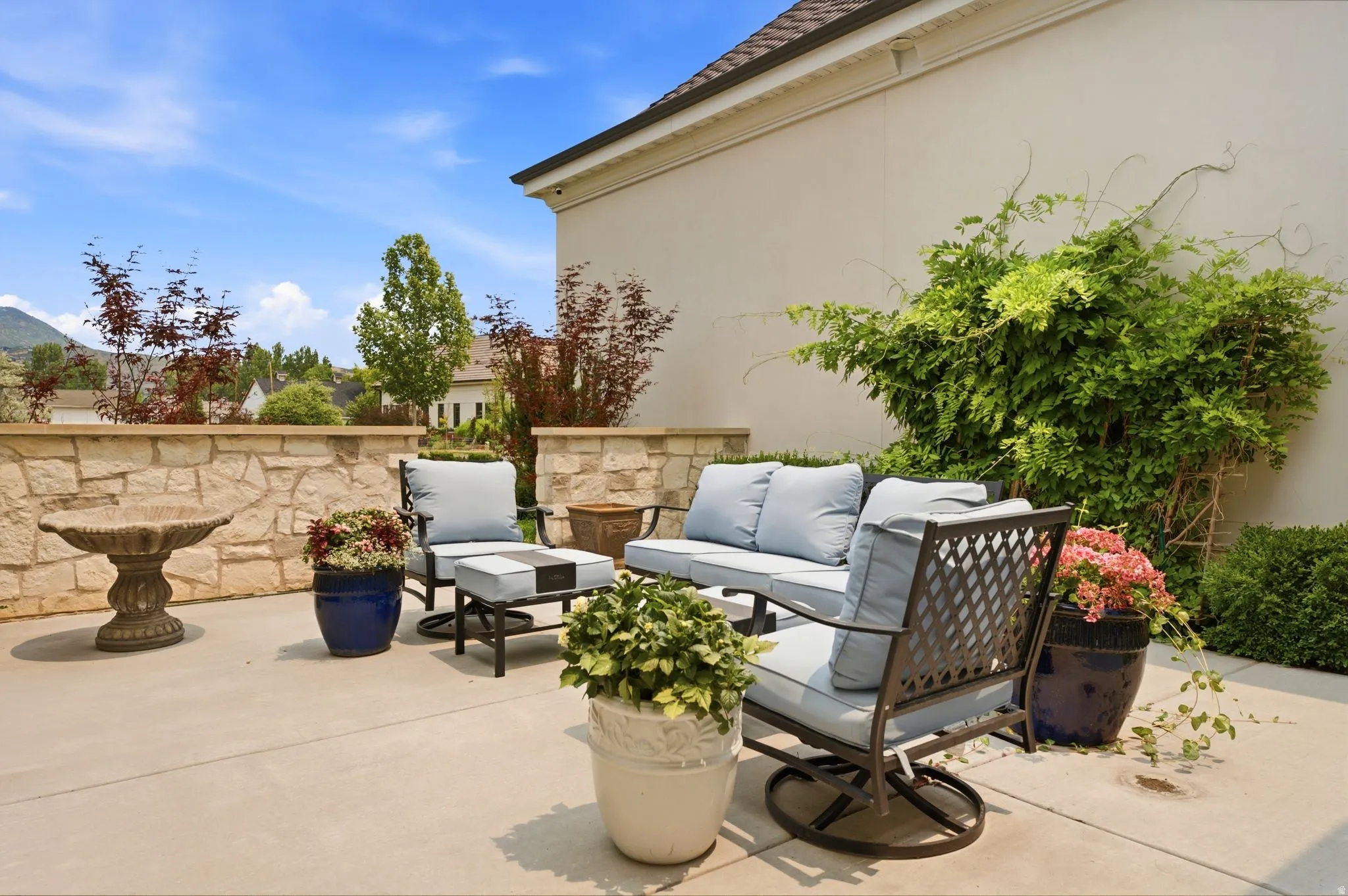 Spacious concrete patio featuring a stone-faced retaining wall
