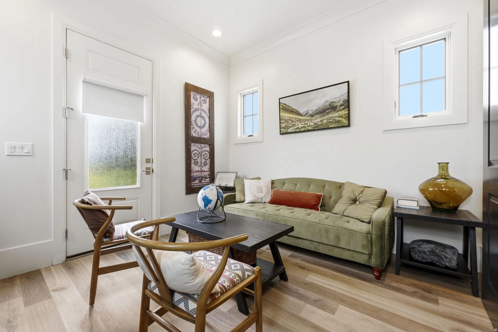 Living area featuring wood-finish flooring, white walls, recessed lighting, and multiple windows