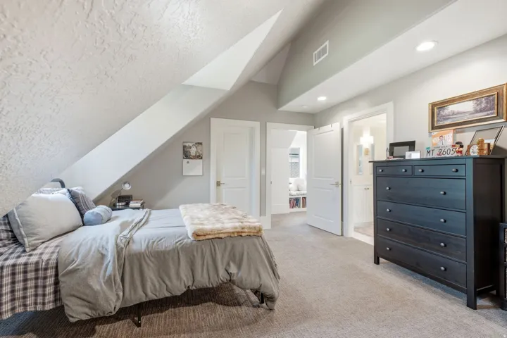 Carpeted room featuring a sloped ceiling, recessed lighting, white trim, and a doorway to an additional space
