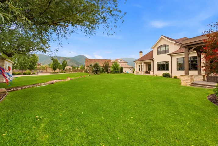 Expansive green lawn bordering a stucco and stone exterior