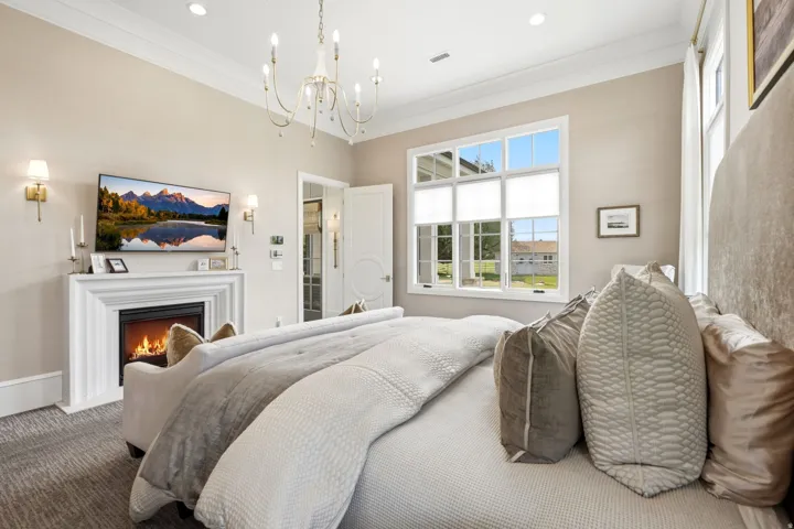 Bedroom featuring a classic white fireplace with a mantle, a multi-pane window, and recessed lighting