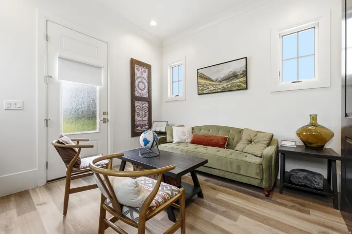 Living area featuring wood-finish flooring, white walls, recessed lighting, and multiple windows