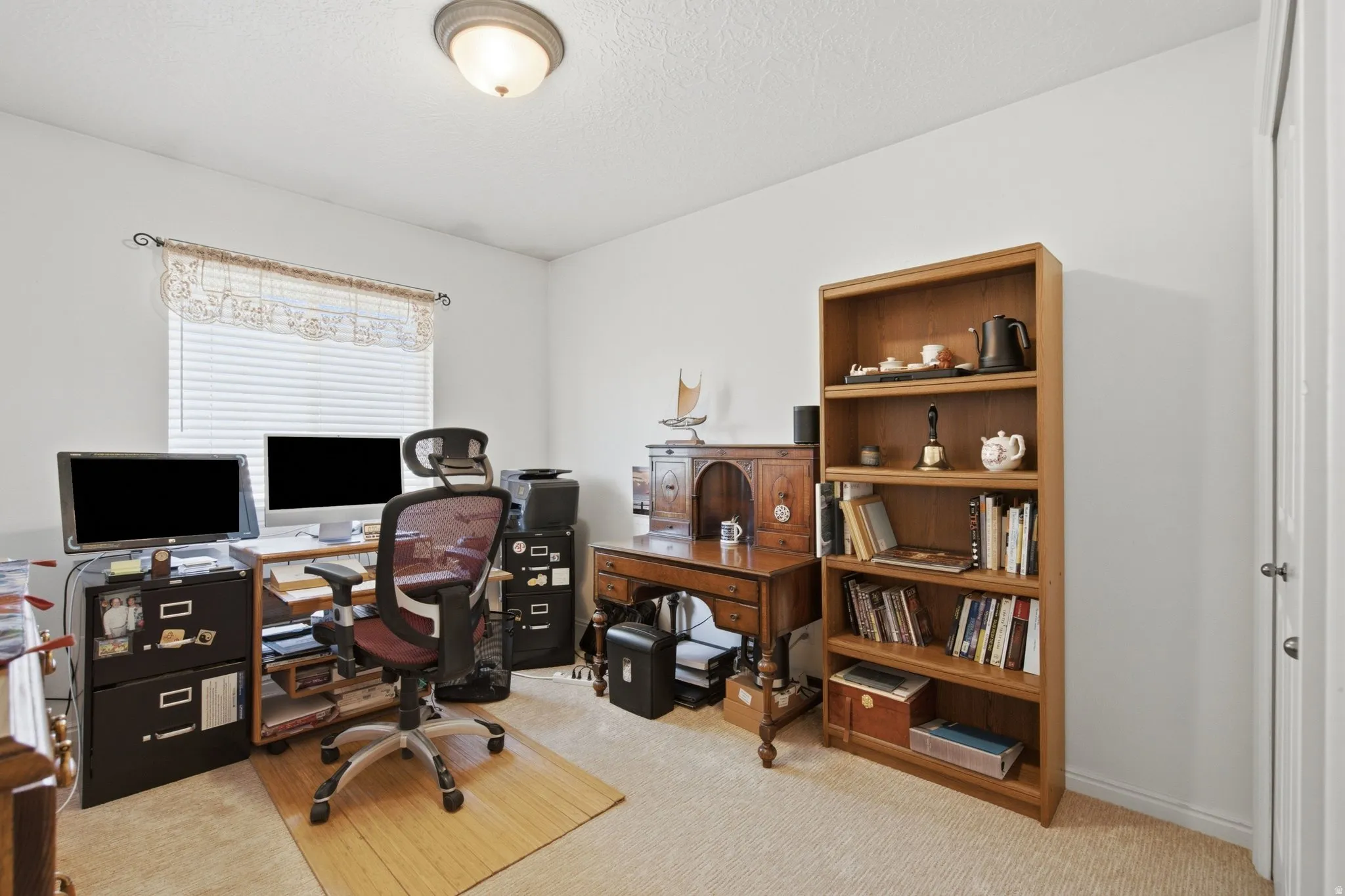 Carpeted room with a ceiling-mounted light fixture