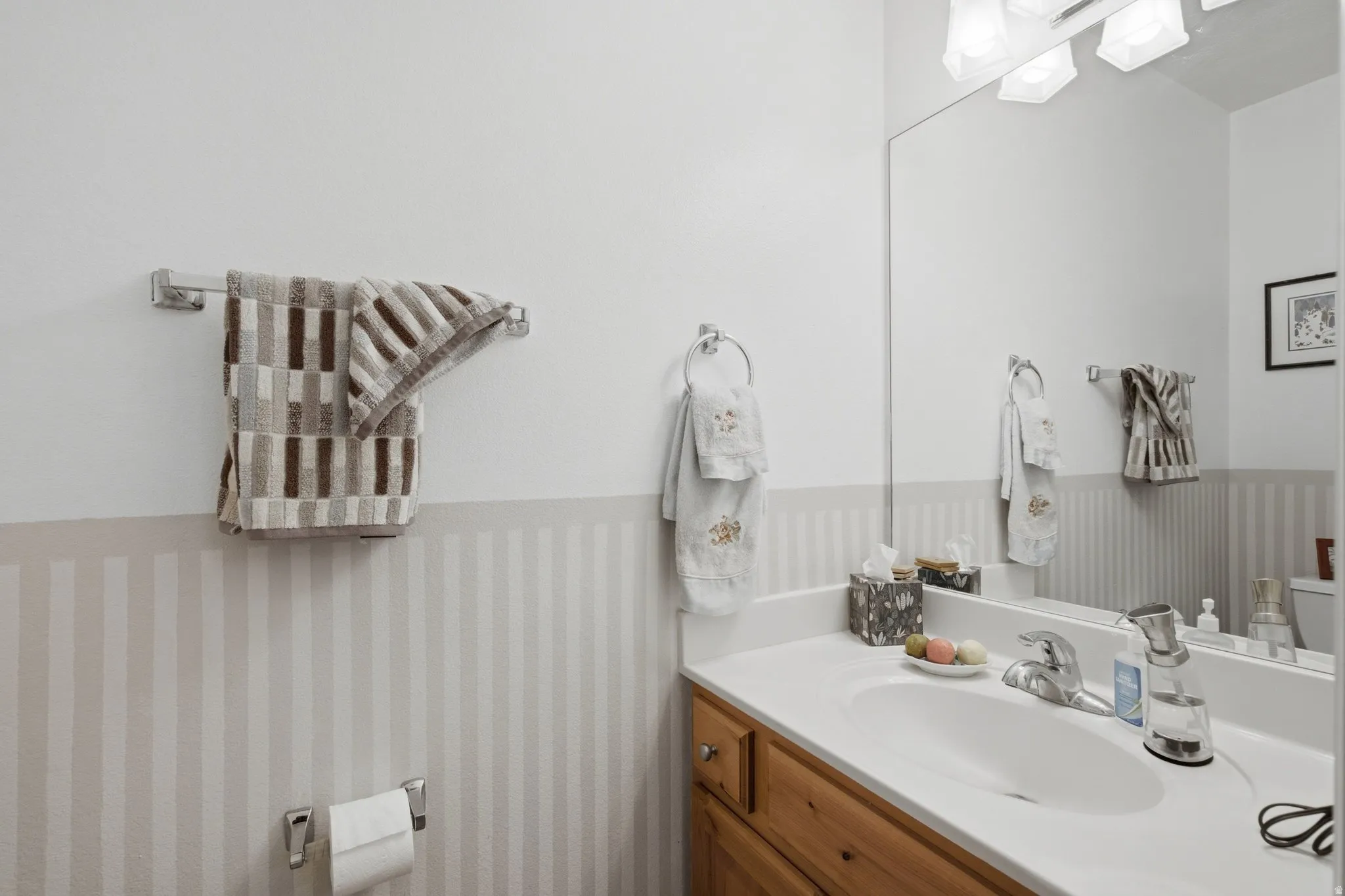 Bathroom vanity with an integrated sink, polished chrome faucet, and wood-finish cabinetry