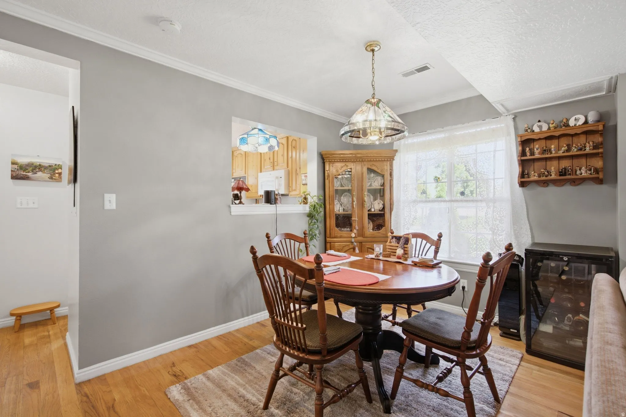 Dedicated dining area featuring wood-finish flooring, a decorative hanging light fixture, and a window with natural light