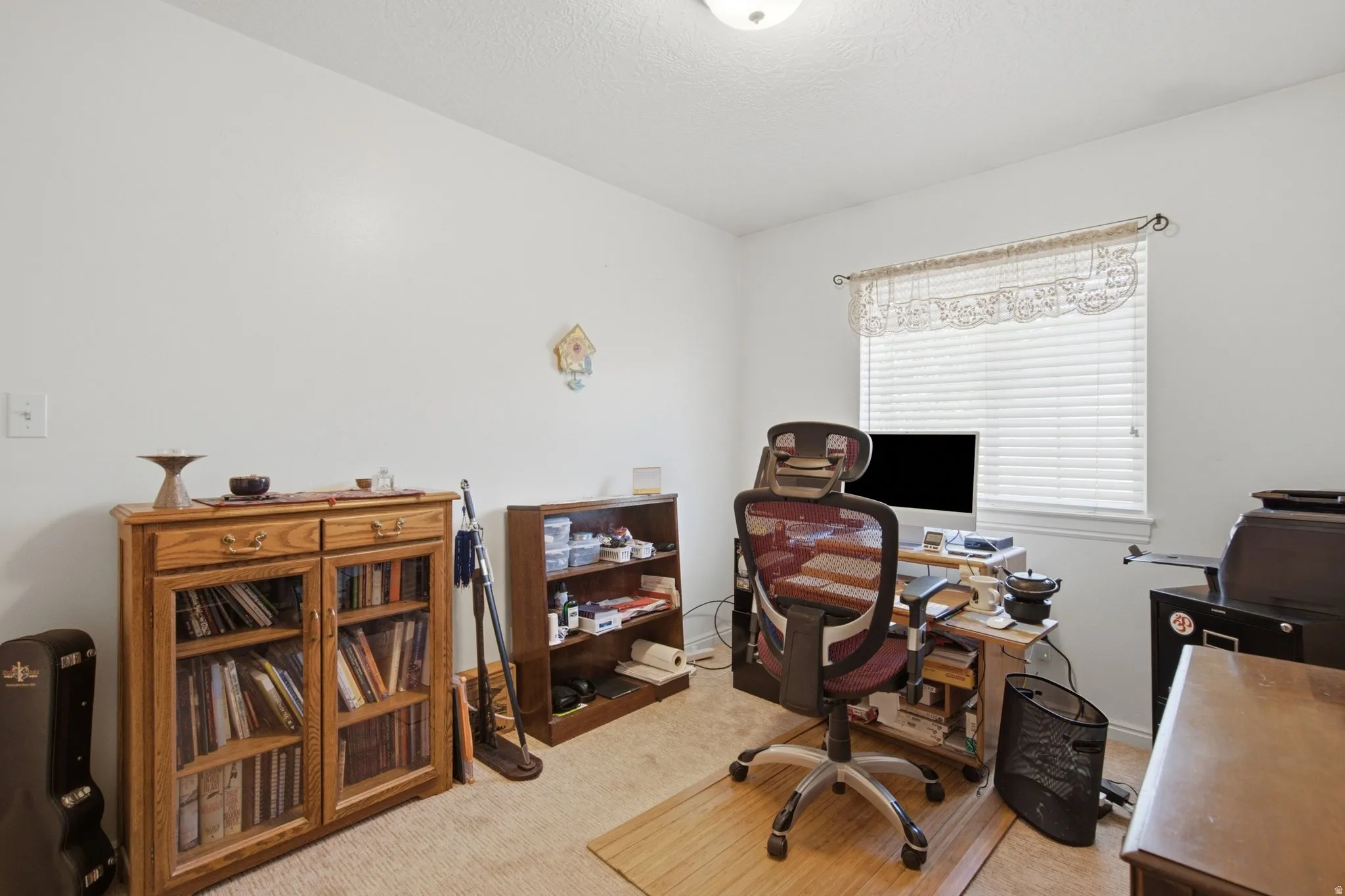 Room with light-colored walls and textured carpet flooring