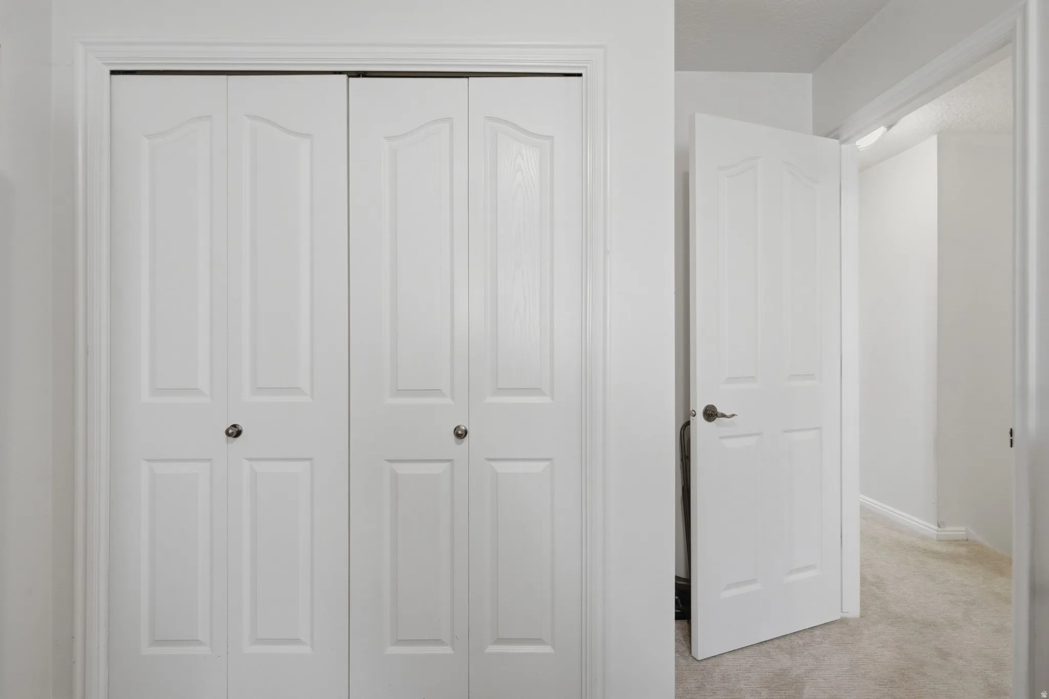 White paneled bi-fold doors with round knobs
