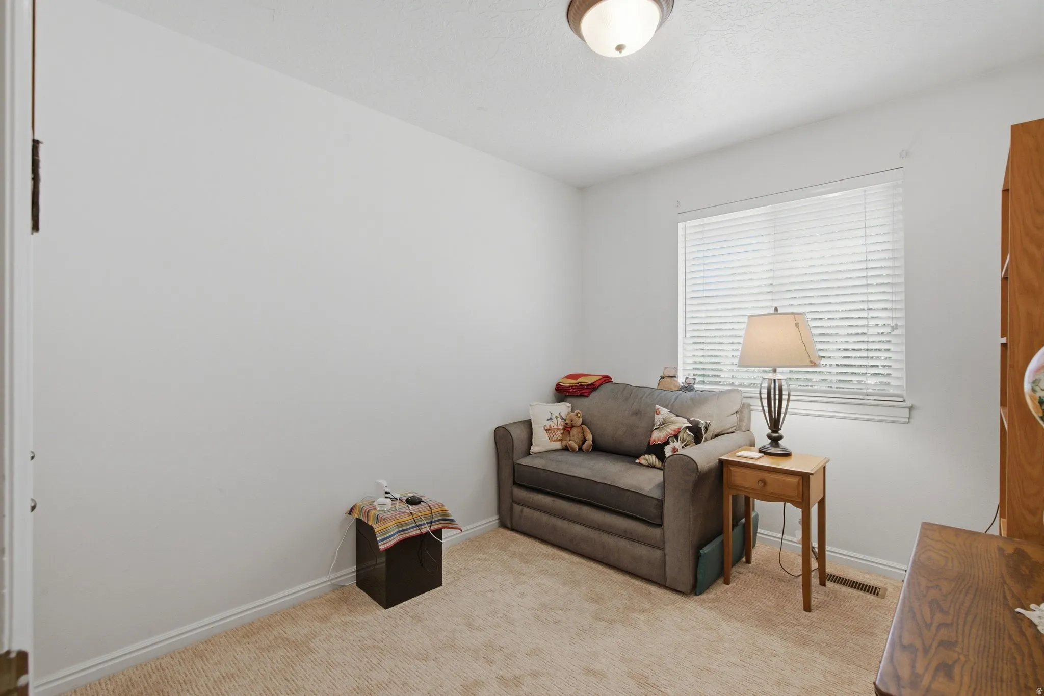 Well-lit room with a single window featuring blinds