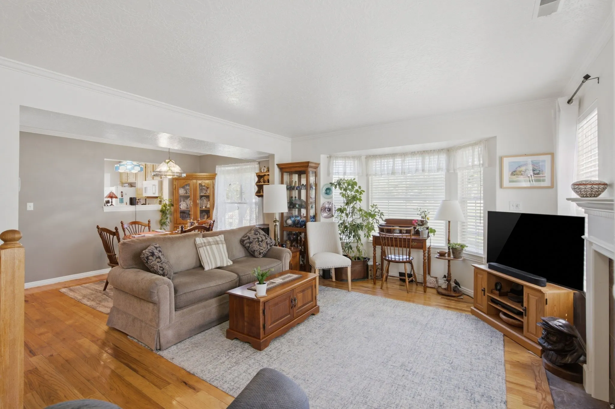 Living area with wood-finish flooring and a large bay window